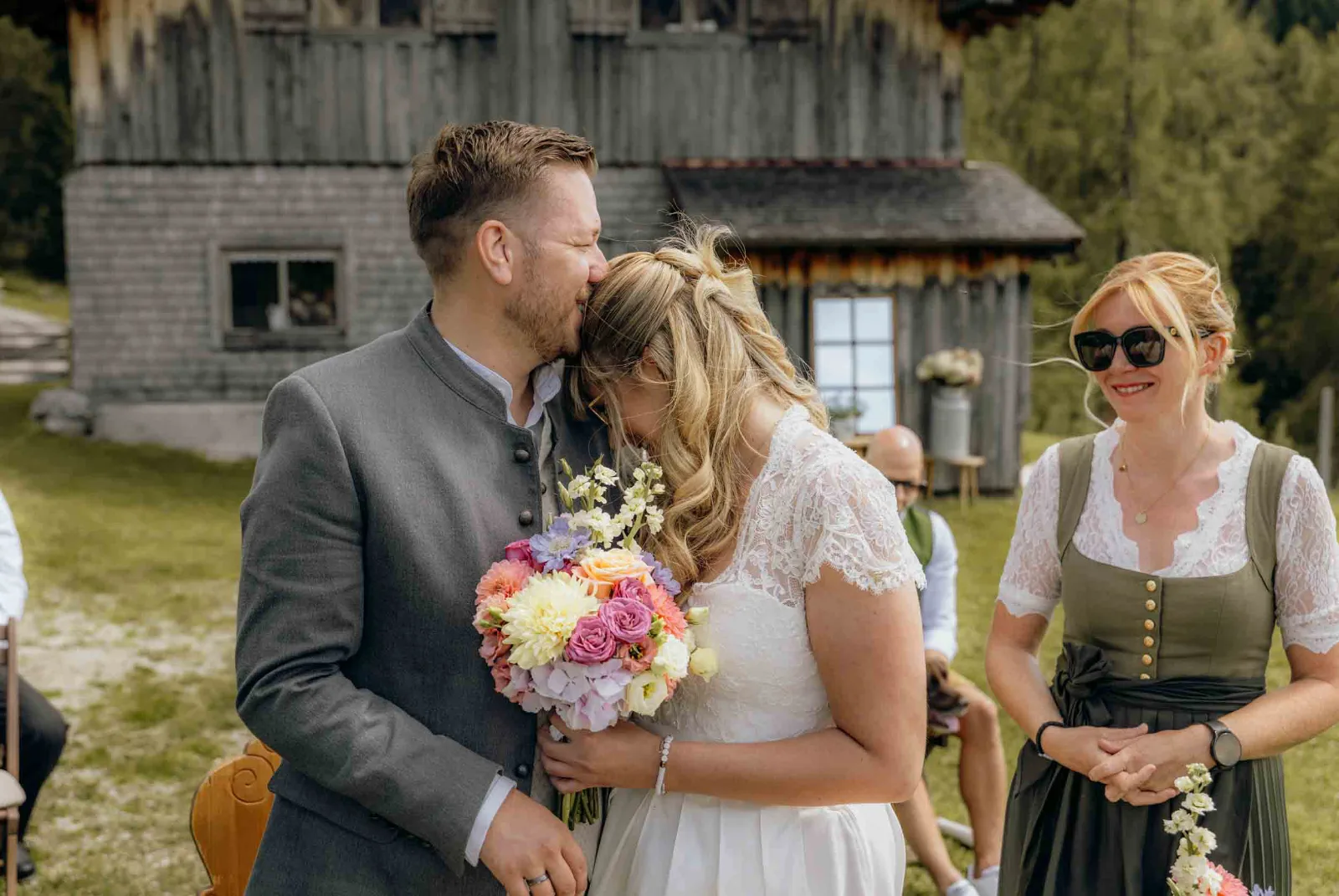 Ein Brautpaar hält sich bei einem Elopement fest, während ich als Hochzeitsfotograf München die persönliche Atmosphäre vor der Loeckwaldhütte festhalte.