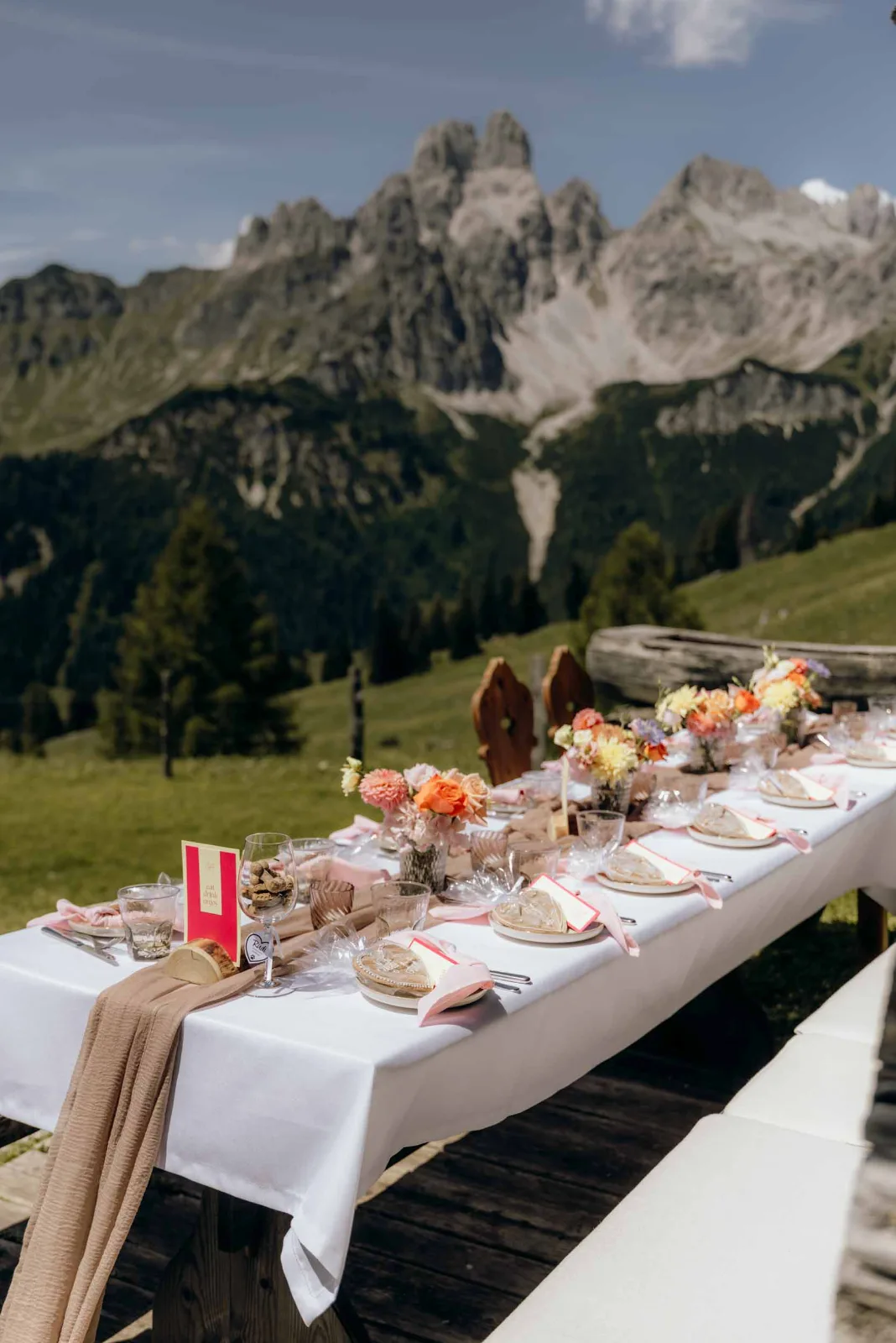 Hochzeitsfotograf München begleite ich das Elopement bei der Löckwaldhütte mit einer gedeckten Tafel vor einer Bergkulisse.