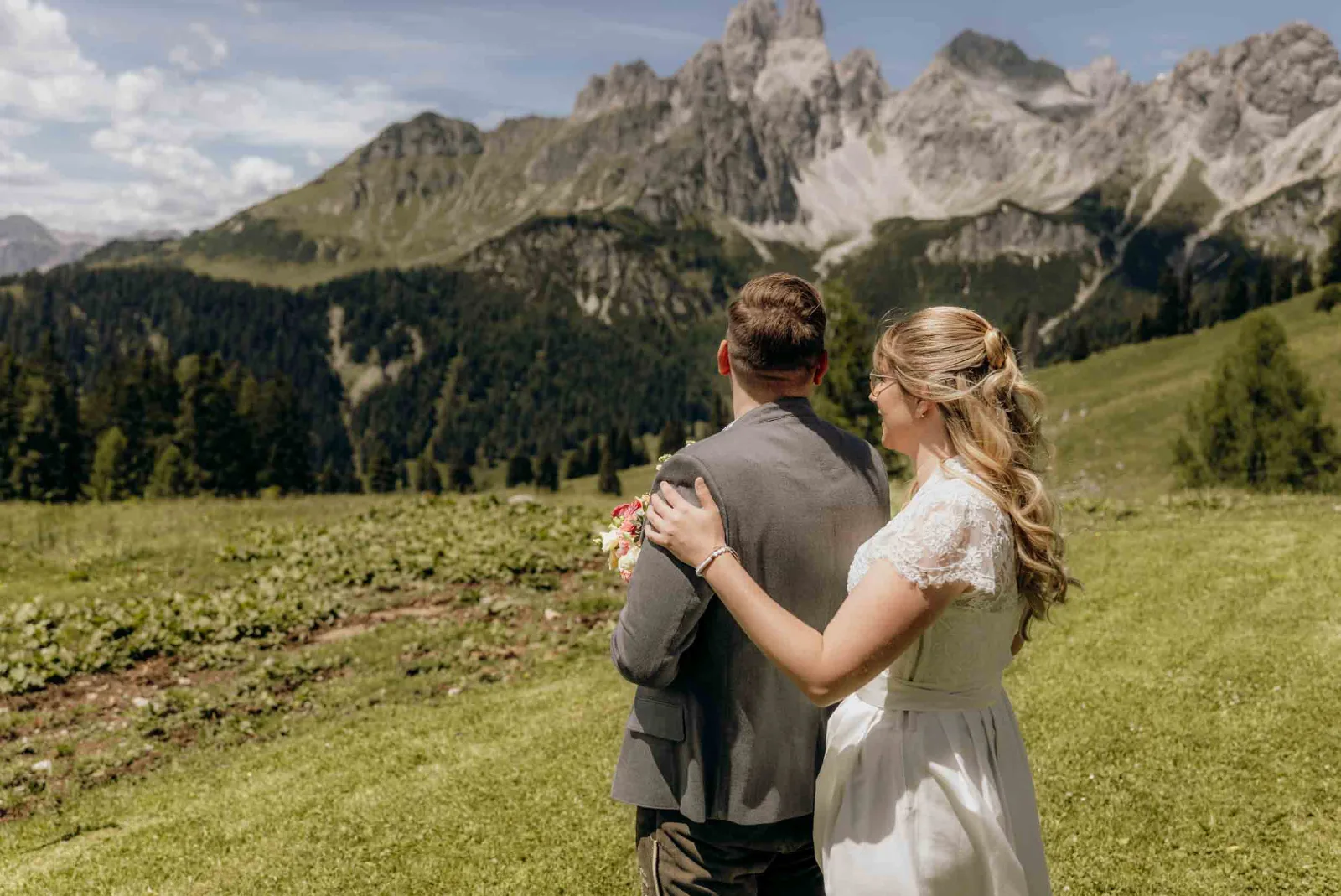 Ein Brautpaar blickt bei einem Elopement gemeinsam auf das Bergpanorama beim First Look, begleitet von MOKATI als Hochzeitsfotograf München.