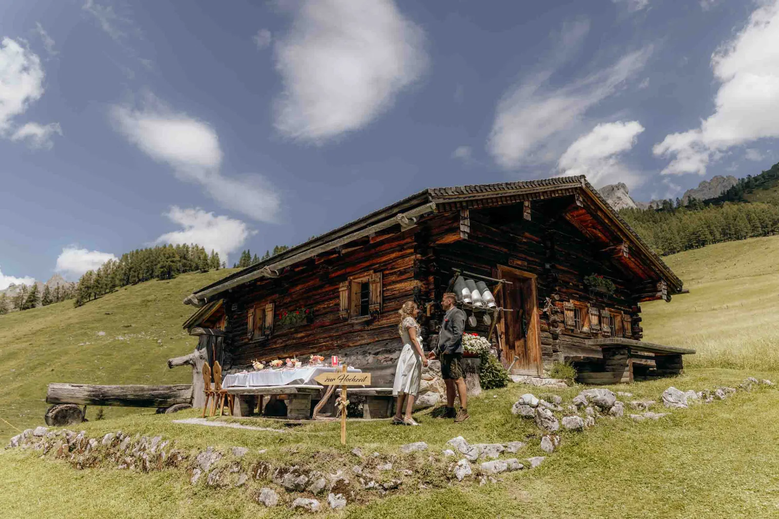 Ein Brautpaar steht vor der Löckenwaldhütte, während wir diesen ruhigen Augenblick in den Bergen für euch festhalten.
