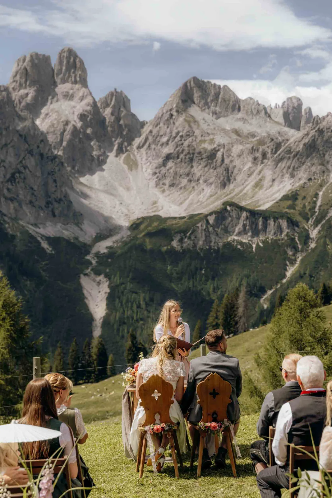 Das Brautpaar sitzt während der Freien Trauung auf der Löckenwaldhütte vor einer imposanten Bergkulisse.